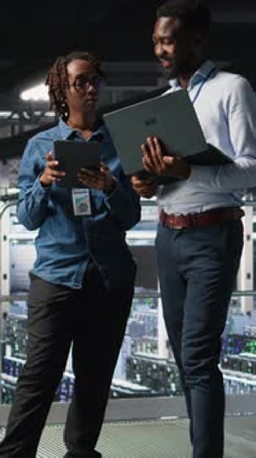 Vertical Video Data Center Coworkers Doing Maintenance Tasks on Laptop