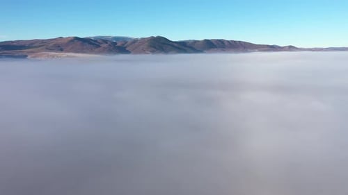 Aerial Drone View Over Mist and Clouds in a Sunny Morning During Sunrise