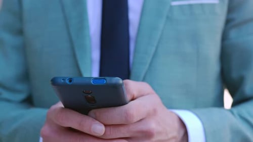 Closeup View of Business Man Hands Using Smartphone Device Outdoors