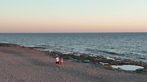 Cute Couple Walking on the Beach at Sunset Time