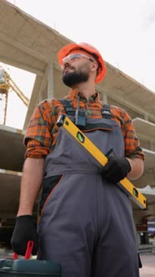 Construction Worker Holding Spirit Level at Building Site