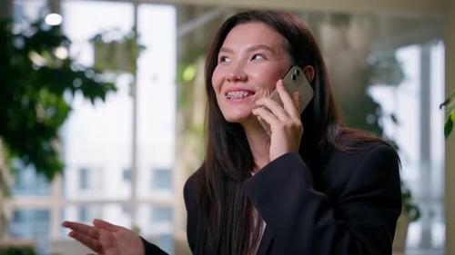 Smiling Woman Talking on Phone in Modern Office