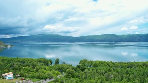 Aerial view Sevan lake with trees and mountains background.