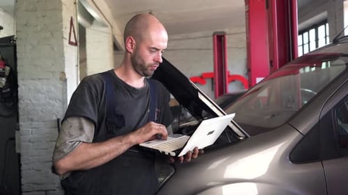 auto mechanic diagnoses a car using a computer. car workshop. close-up