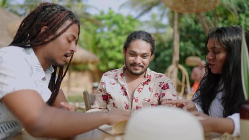 Diverse Friends Laugh Peruse Menu at Sunny Tropical Cafe Trio Enjoys Gourmet Meals Selection