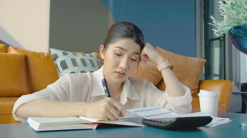 Stressed Young Woman Calculating Finances at Home