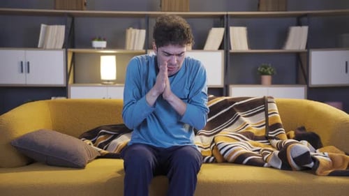 Man Feeling Sick, Cold, and Shivering on Couch