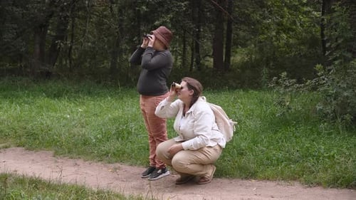 Mother and Son are Birdwatching in Park with Binoculars