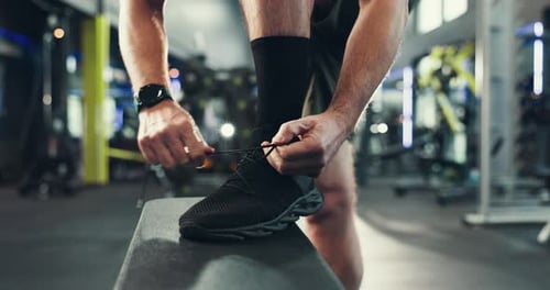 Hands, shoes and laces in gym for fitness, run or start exercise routine with man for health
