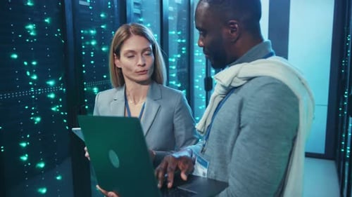 Technicians Collaborate in Modern Server Room