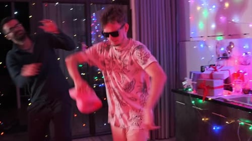 Party with friends at home at night guys dancing to music in decorated room with lights having fun