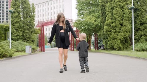 Famille heureuse. Jeune mère enceinte avec son fils dans le parc. La famille passe du temps ensemble