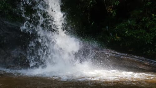 Waterfall slow motion footage, flowing water stream in a tropical rainforest in Thailand.