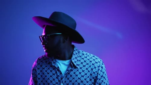 Smiling man in floral shirt with hat and glasses