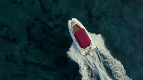 Close up shot over speed boat with a red roof top passing through clear turquoise magical ocean.