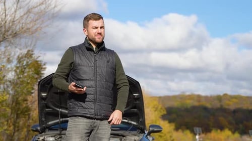 Sad Man Standing Speak on Phone Near the Broken Car Opened the Hood Road Help Repair Stress Problem