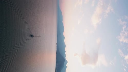 Sailboat Gliding on Calm Water at Sunrise