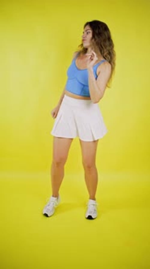 Smiling Woman Dancing in Front of a Yellow Background