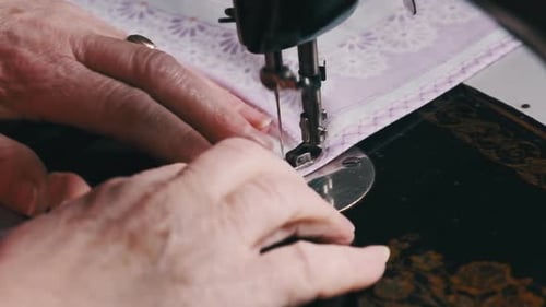 Senior Hands Sewing Fabric with Vintage Machine