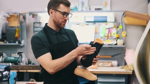 Trägt schwarzes Material. Techniker, der im modernen Labor mit Prothesen arbeitet