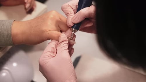 Woman Receiving Manicure from Aesthetician in Nail Salon