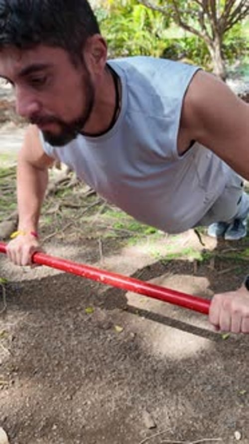Junger Mann trainiert Liegestütze im Park im Freien