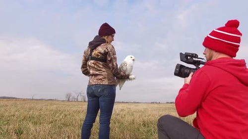 Woman Holds White Owl as Camera Films in Field