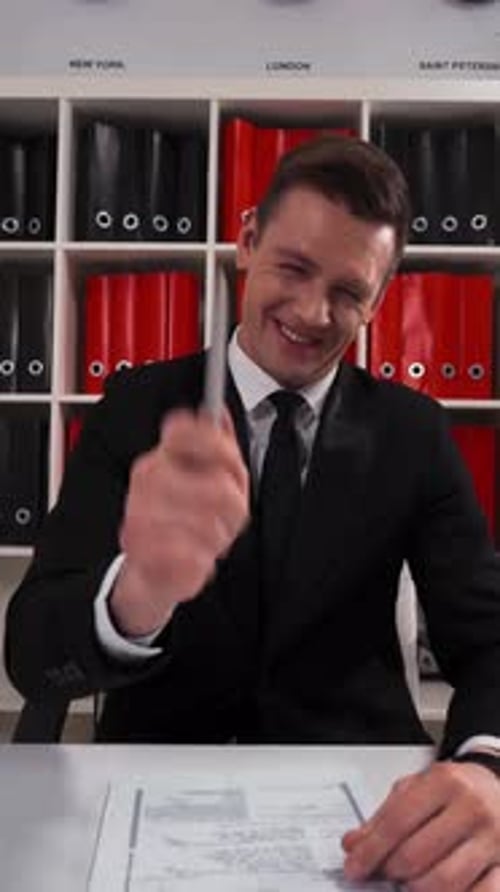 Vertical d'un jeune homme d'affaires pointant du doigt et riant avec votre blague amusante