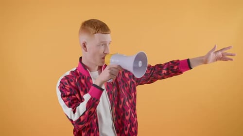 Young Adult Speaking into Megaphone on Orange Background