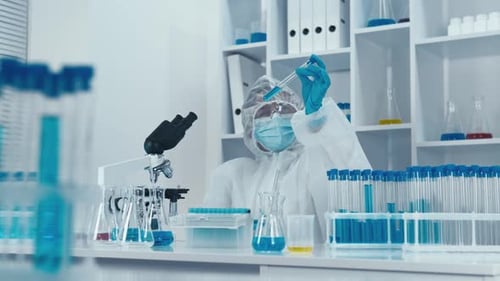Scientist Experimenting with Blue Liquid in Modern Lab