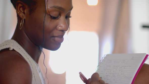 Woman reading notes from notepad, focusing on written content indoors ...