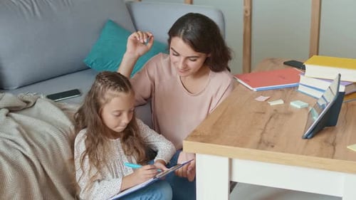 Mother Helping Young Daughter with Schoolwork at Home