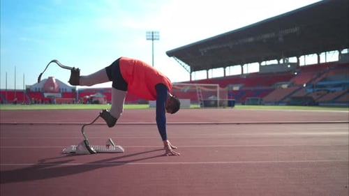 Disabled athletes prepare in starting position ready to run on stadium track