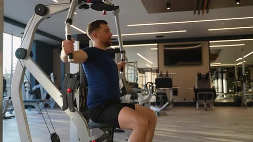 Man Training Chest on Butterfly Gym Machine