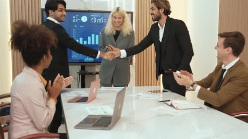Business Meeting Ends with Handshake and Applause