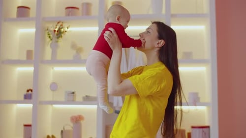 Woman Holds Up Baby in Bright Room