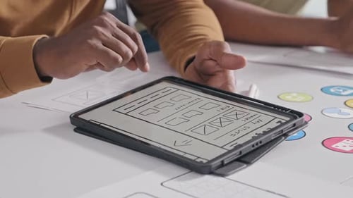 Colleagues Discussing Mobile App Layout on Digital Tablet