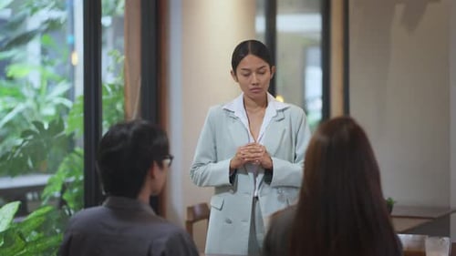 Young woman in suit gives presentation indoors