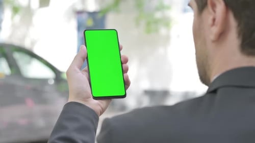 Young Businessman Using Phone with Green Screen Outdoor
