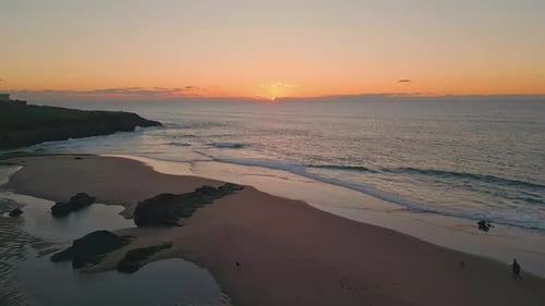 Sunset Illuminating Rocky Beach in Tranquil Aerial Shot Dawn Cast Peaceful Hue