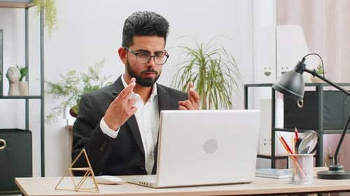 Stressed Businessman at Desk Closes Laptop