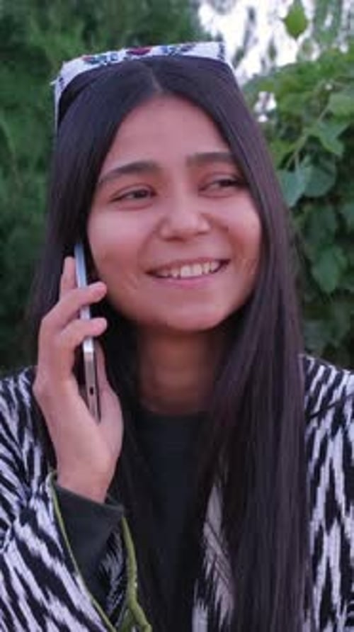 Young Woman Smiling While Talking on Phone