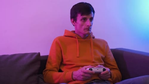 Young Adult Gaming on Couch with Controller Indoors
