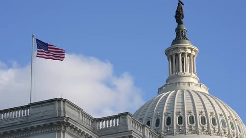 United States Capitol Building with American Flag on Clear Day