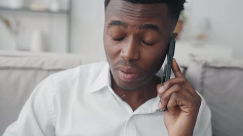 Young Man Talking on Smartphone in Living Room