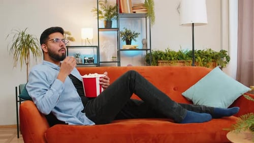 Adult Man Lying on Couch and Eating Popcorn