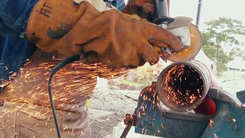 Blacksmith or welder professional, smooths steel and iron,in extreme slow motion,to make the surface