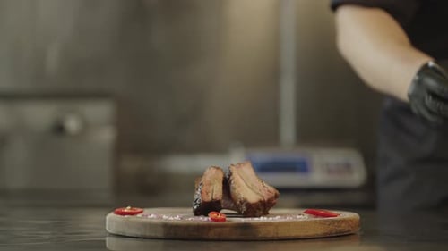 Chef Places Barbecue Ribs on a Wooden Platter