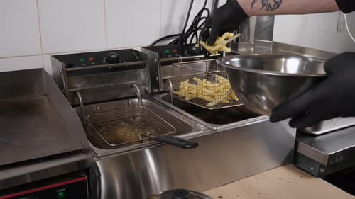 Closeup of the Chef Cooking French Fries in the Restaurant Kitchen