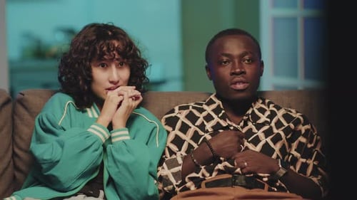 Woman and Man Watching TV on Couch Together